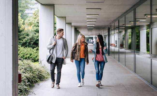 drei gehende Studierende im Außengang Keplergebäude