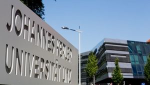 Schild mit JKU Linz Logo bei Haupteinfahrt des Campus