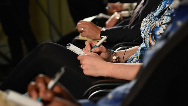 Person taking notes during a conference.