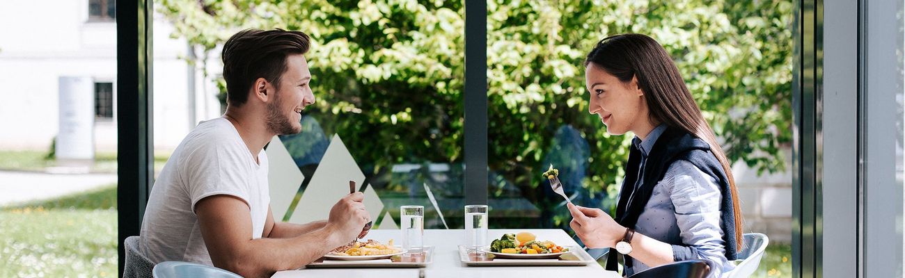 zwei Studierende beim Essen in der Mensa