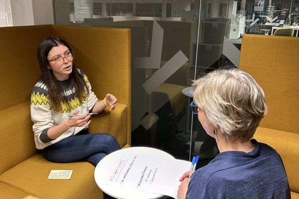 zwei Frauen sitzen und diskutieren in eine orangenen Sitzinsel im LIT Open Innovation Center Linz