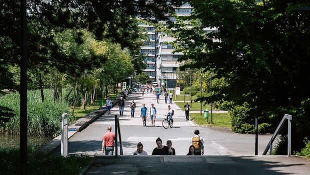 Weg zwischen Teich und Keplergebäude mit Menschen