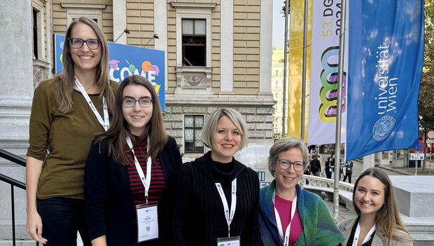 5 Frauen stehen auf der Stiege vor der TU Wien, im Hintergrund die Fahne mit dem Kongress-Logo