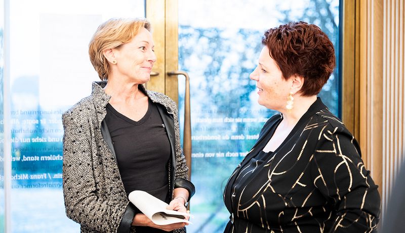 Landesrätin Martina Rüscher beim Sektempfang mit Marion Kaufer, Leiterin der Vorarlberger Landesbibliothek